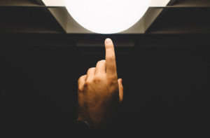 Finger touching a light bulb to emphasise the innovation of marketing compliance technology